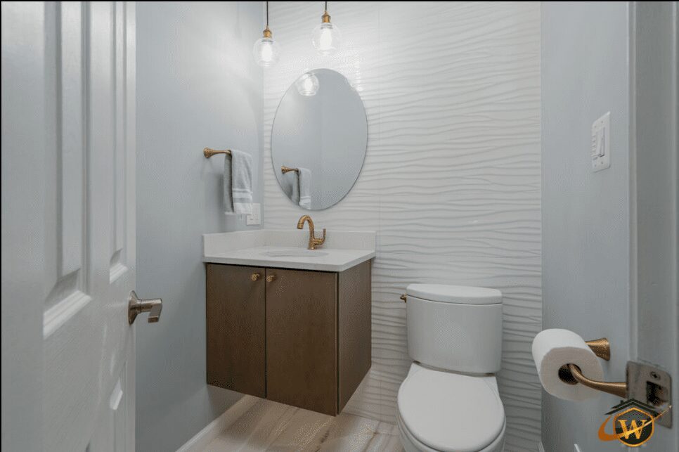 Modern bathroom with floating vanity, round mirror, and white toilet.